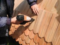 Schindeln werden an die Mühlenkappe genagelt