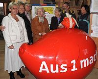 Fröhliche Vereinsmitglieder am Sparschwein